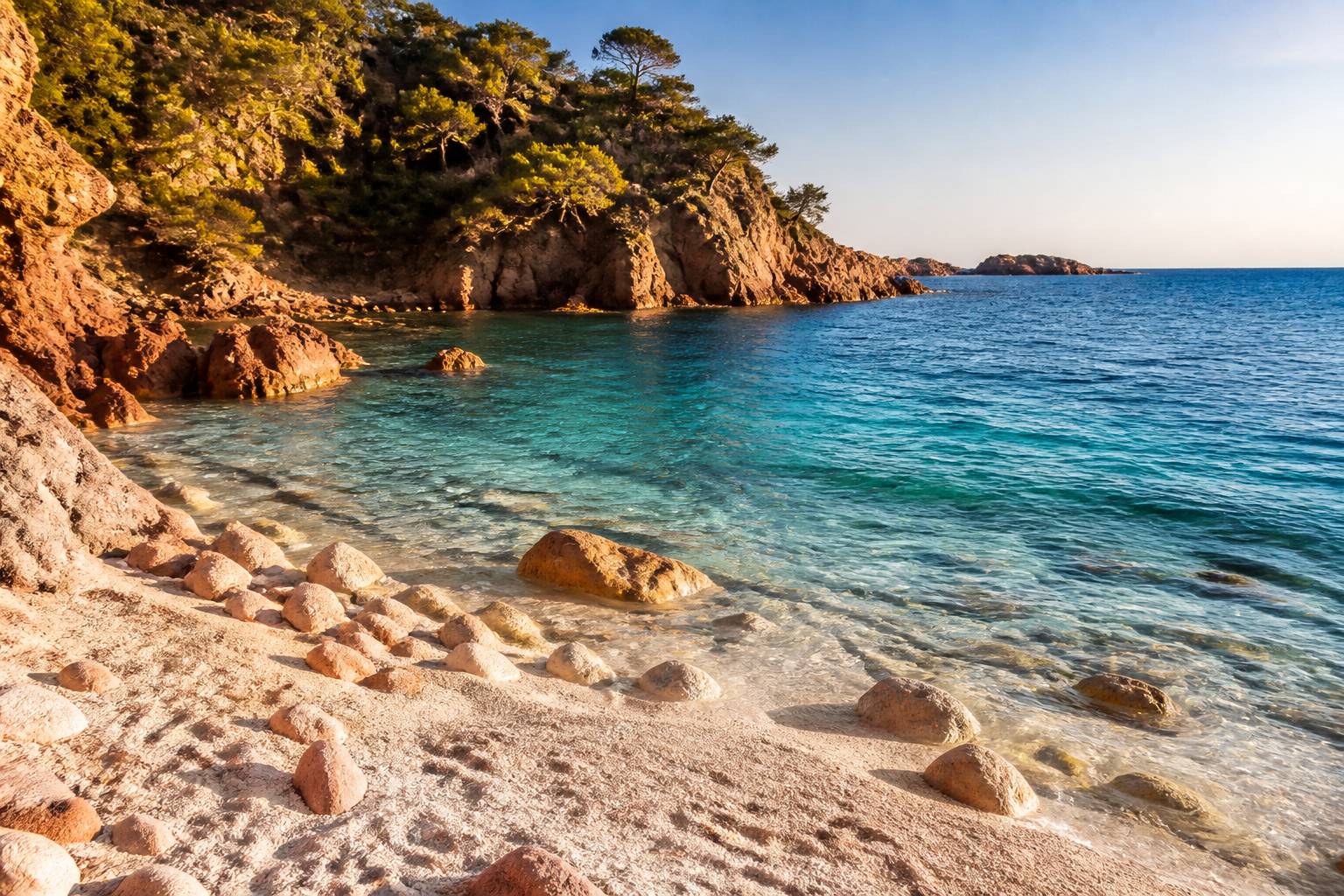 Plage de galets et sable au bord de l'eau turquoise